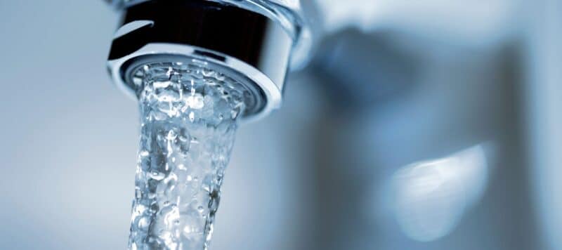 Flowing water from a modern faucet, showcasing clean and steady water pressure