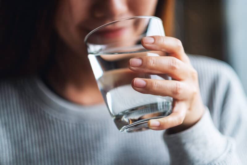 closeup image of a woman drinking a glass of water