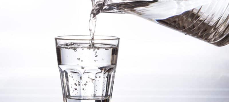 pouring water into a cup from a pitcher